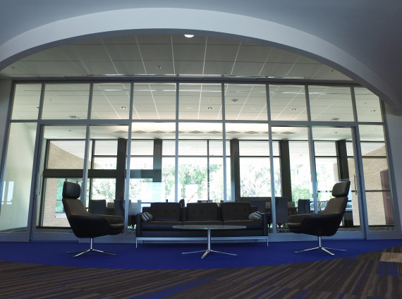 Front lobby with floor to ceiling windows and black lobby furniture at Info Tech, a Gainesville based company.