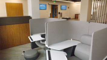 Enclosed chairs with movable trays for personal space use