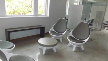 Four grey Steelcase Jenny chairs placed around a grey topped center table.