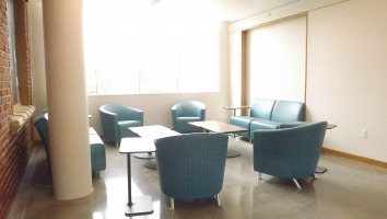 Jenny lounge seating by steelcase with two coffee tables, chairs colored in a teal greenish-blue.