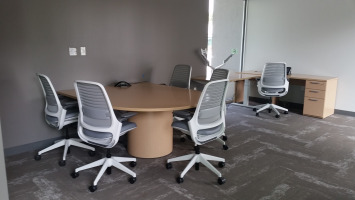 Four mesh back chairs placed around an acorn colored table.