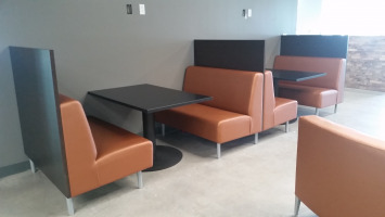 Booth seating colored orange with black tables.