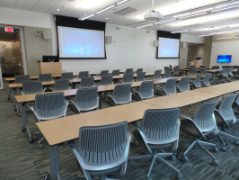 Rows of Cobi chairs in a classroom setting with two monitors at the front of the room.