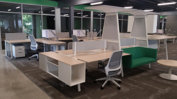 Group desking area with mesh back office chairs and a decorative high hanging shelf