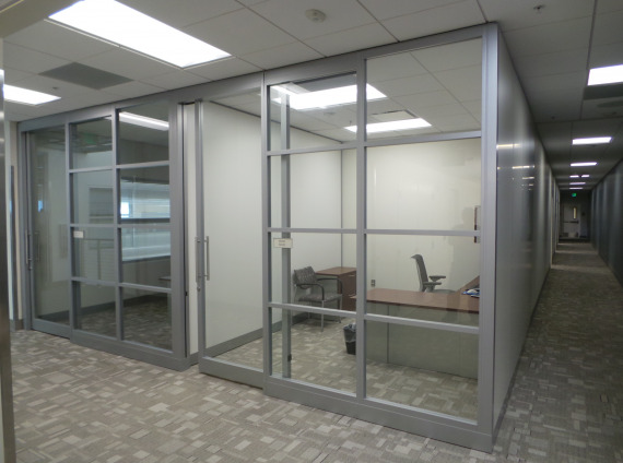 Privacy walls creating separated office space with a guest chair, a task chair, a desk and a storage cabinet.