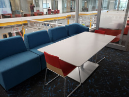 White rectangle lounge table with red chairs and blue lounge seating.