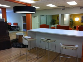 White central lobby location with three stools and a counter in white.